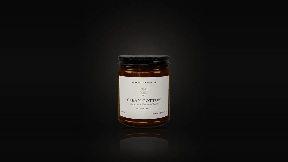 Clean Cotton soy candle in an amber glass jar with a black lid