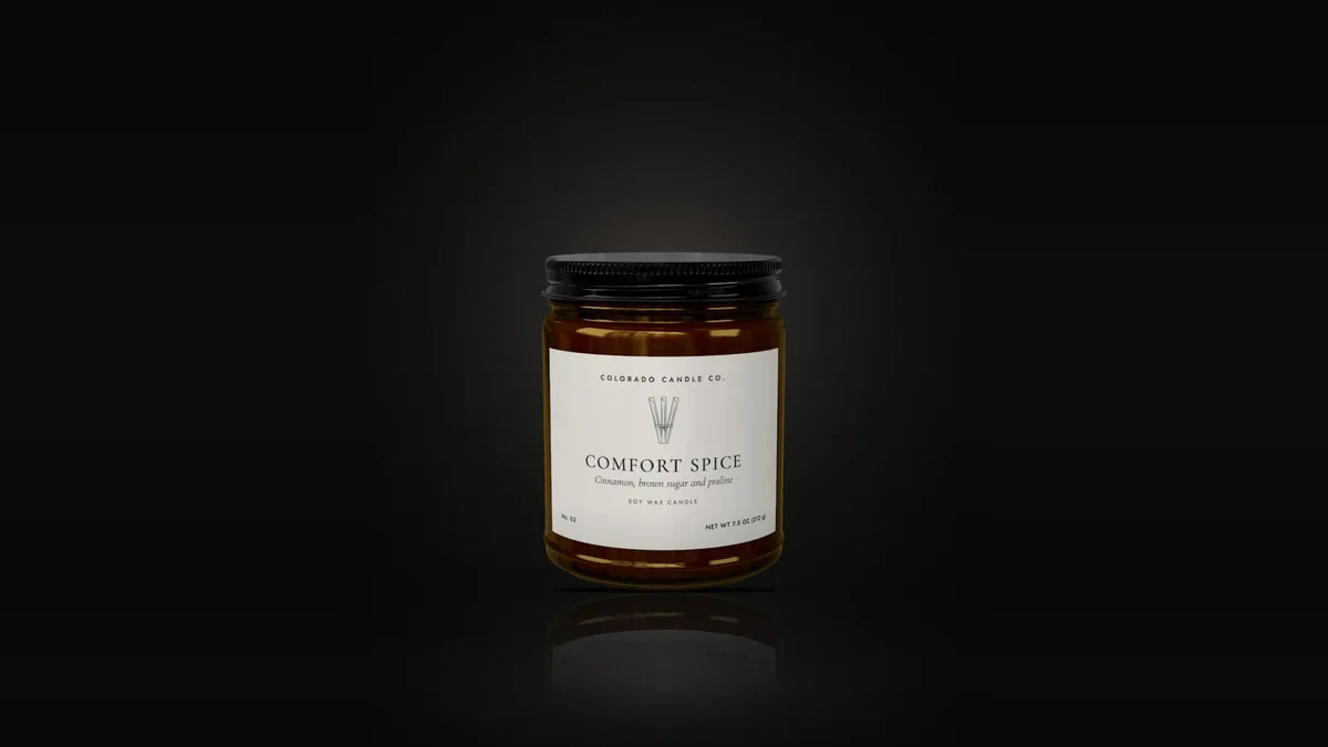 Comfort Spice soy candle in an amber glass jar with a black lid