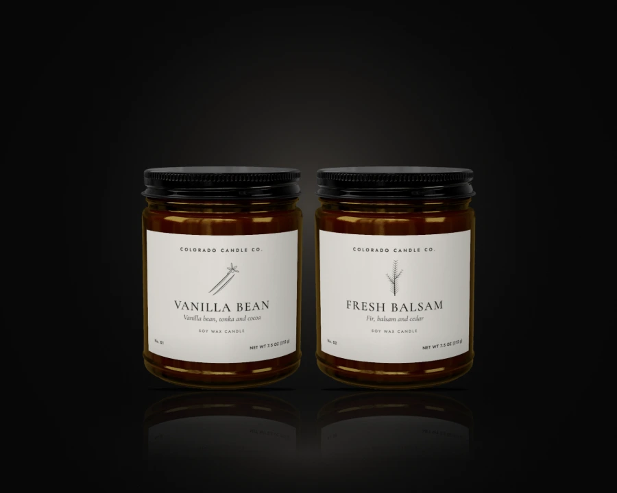 Two large soy candles in amber glass jars with black lids, Vanilla Bean and Fresh Balsam